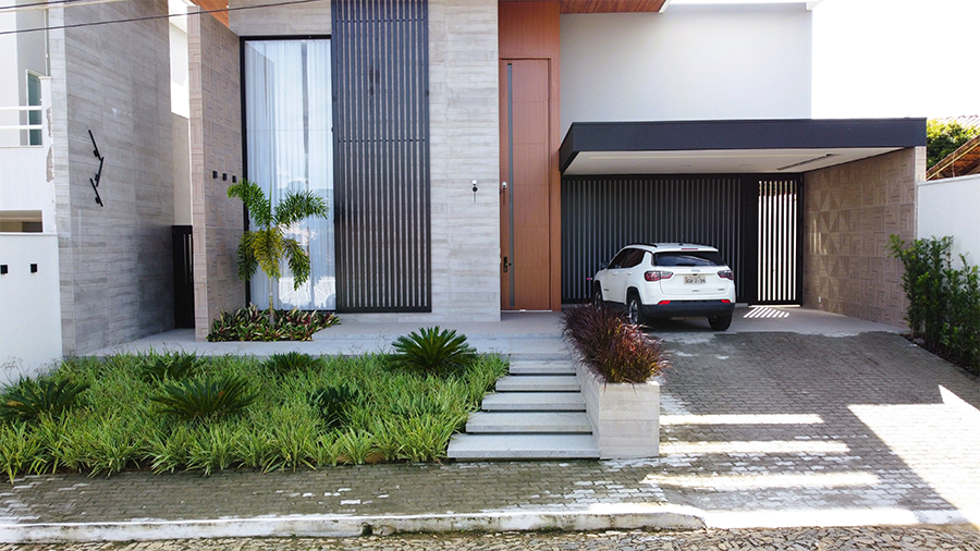 Paisagismo residencial por Studio Julio Sousa Paisagista| Fachada da casa com canteiro de pinheiros-de-buda 